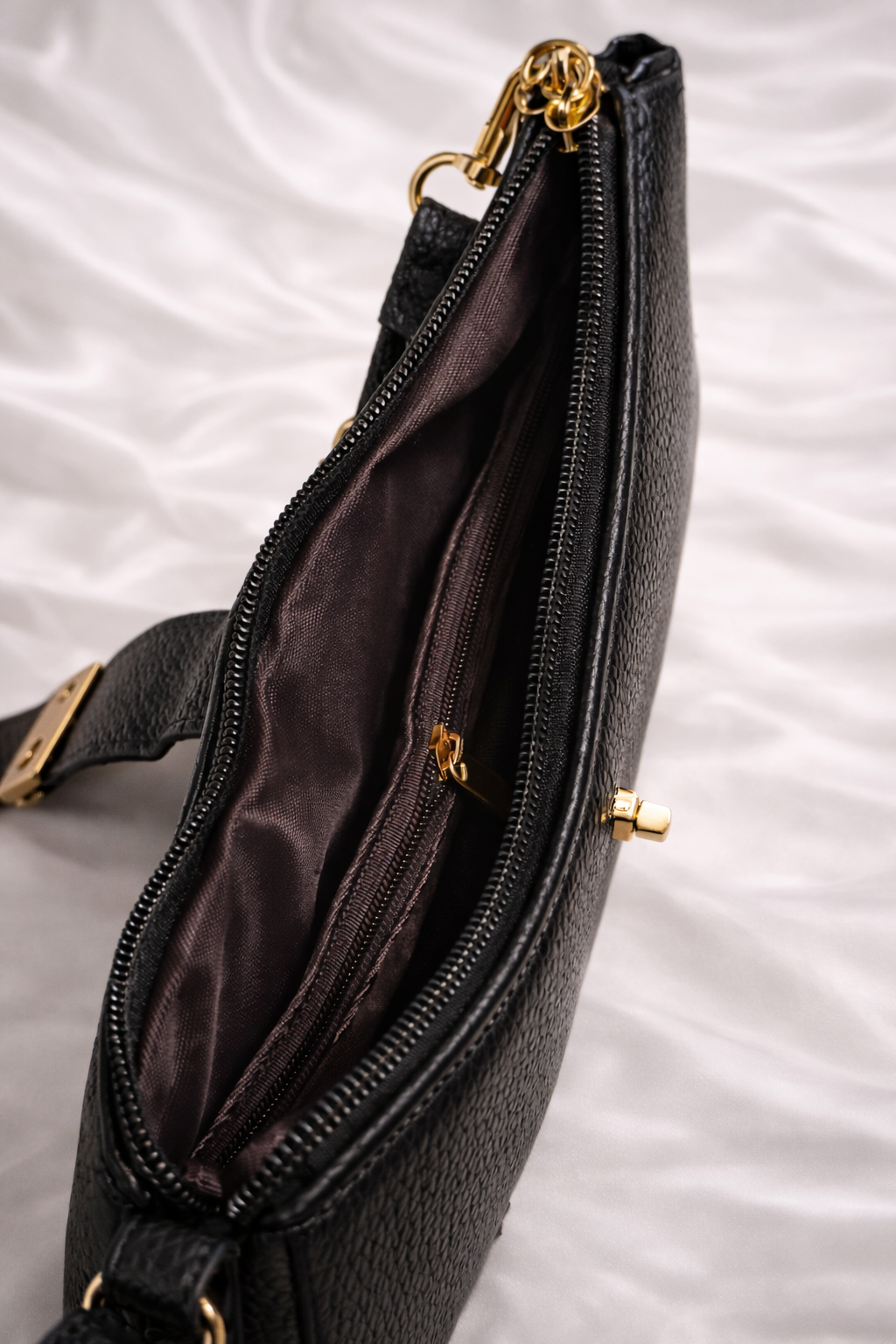 Spacious compartment of black crossbody bag showing enough space for phone and wallet