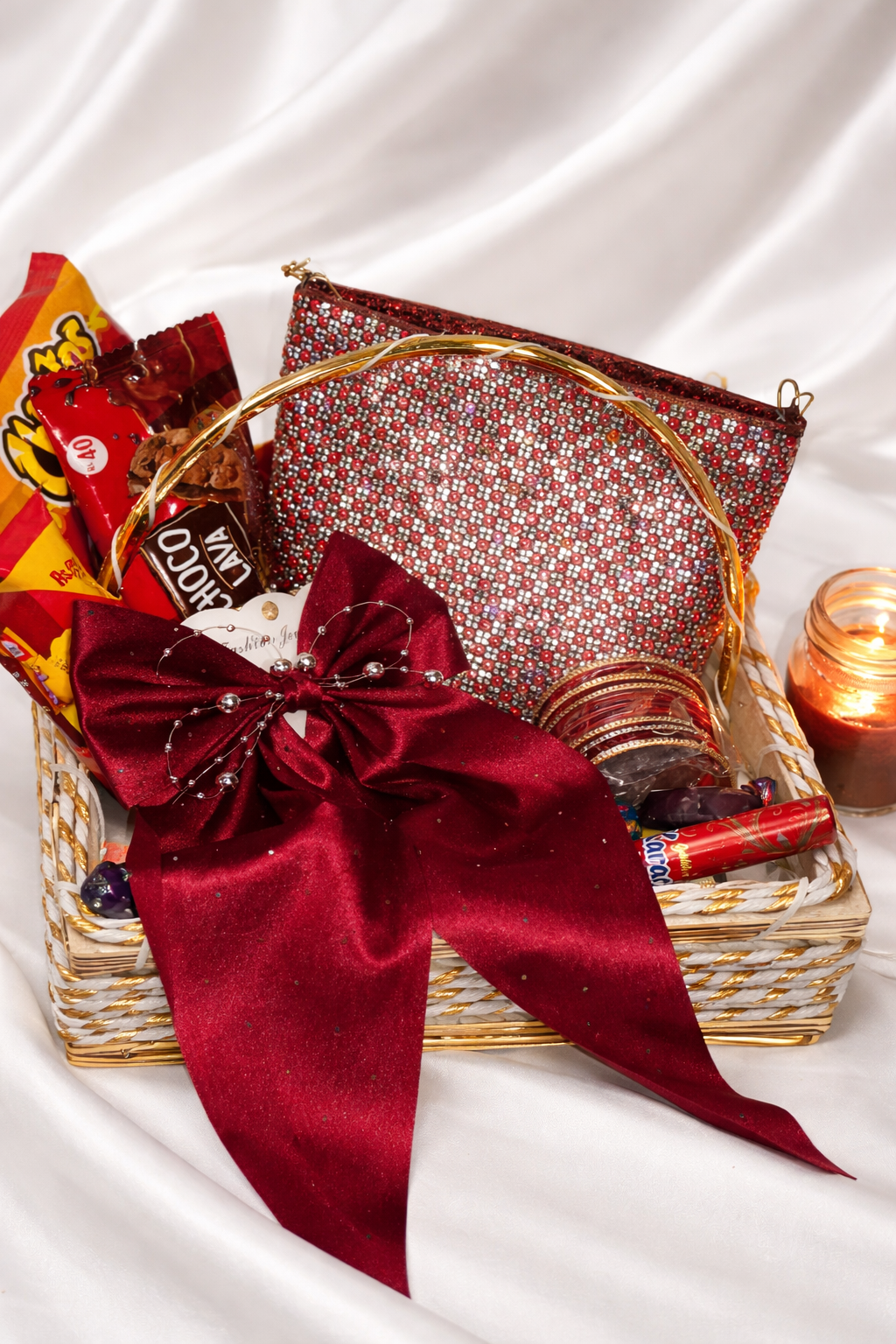 Gift basket with a red bow, candy, and a small bag on a white background