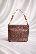 Rose gold glitter handbag with pearl handle on a white background