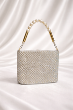 Silver beaded handbag with pearl handle on a satin background