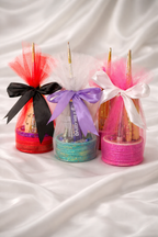Decorative bottles with colorful ribbons and bows on a white fabric background