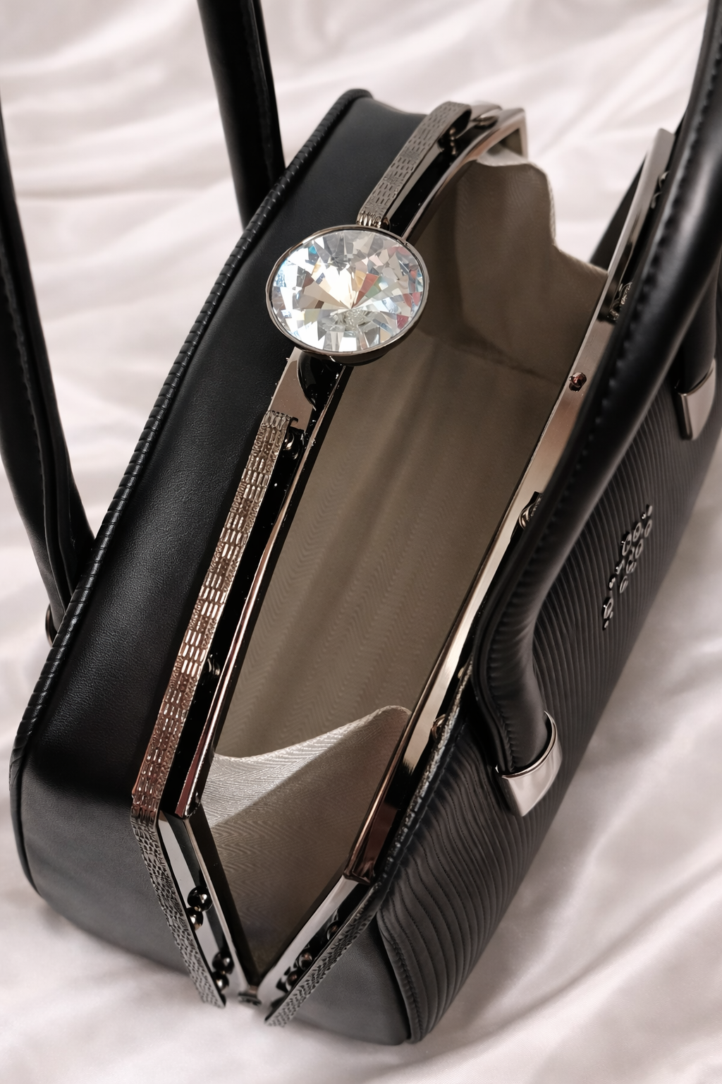 Spacious interior of black leather bag showing warm lining and metal frame with crystal moon at the top