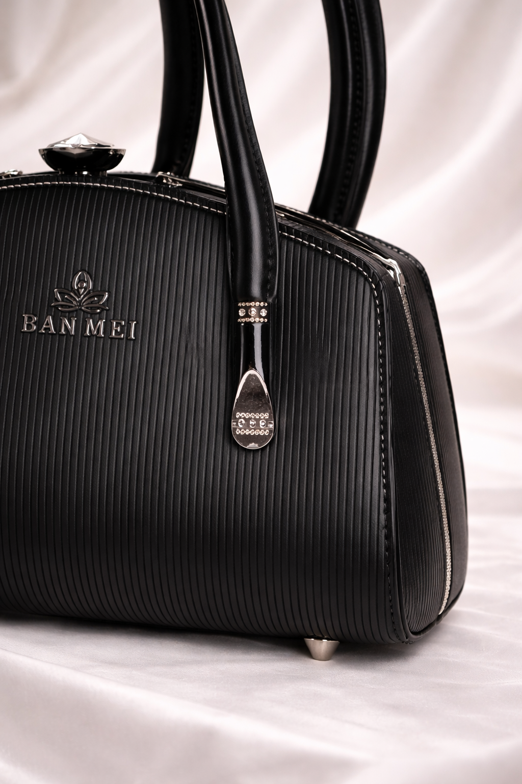 Black gunmetal crescent moon rings and vertical stripe texture on luxury black bag