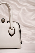 Close-up of rhinestone frame and pearl connector handles on Silslah white handbag
