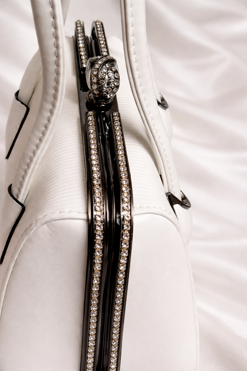 Close-up of rhinestone frame and pearl connector handles on Silslah white luxury handbag 