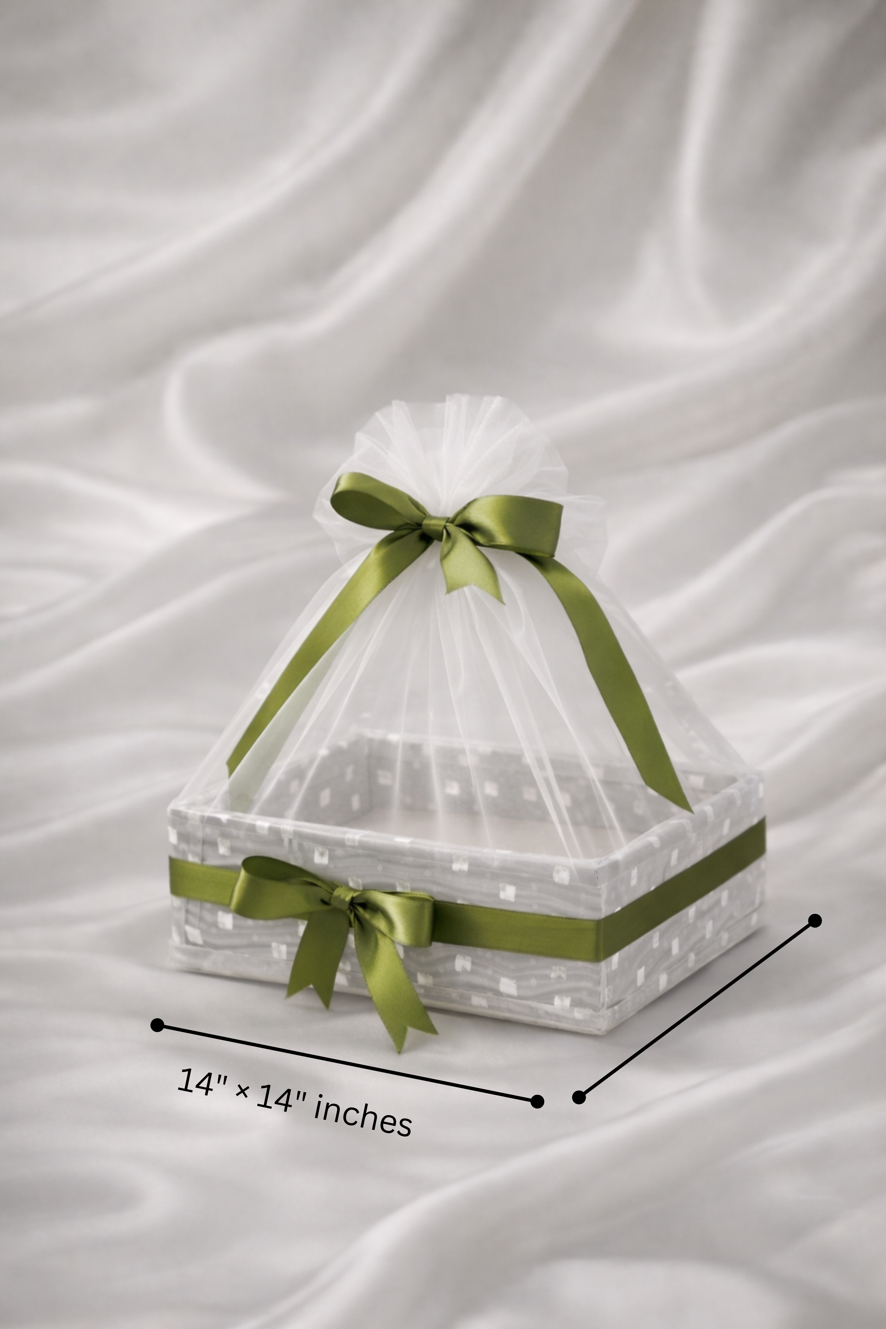 Decorative box with green ribbons on a white fabric background