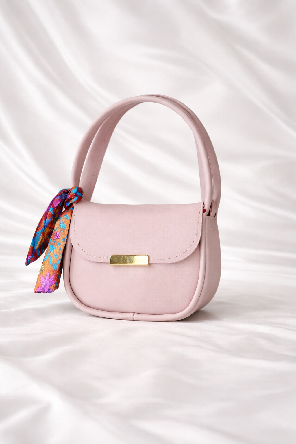 Close up of silk scarf handle and gold hardware on Silslah mini handbag