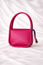 Close up of a Silslah mini handbag with silk scarf on handle and gold flap for little princess