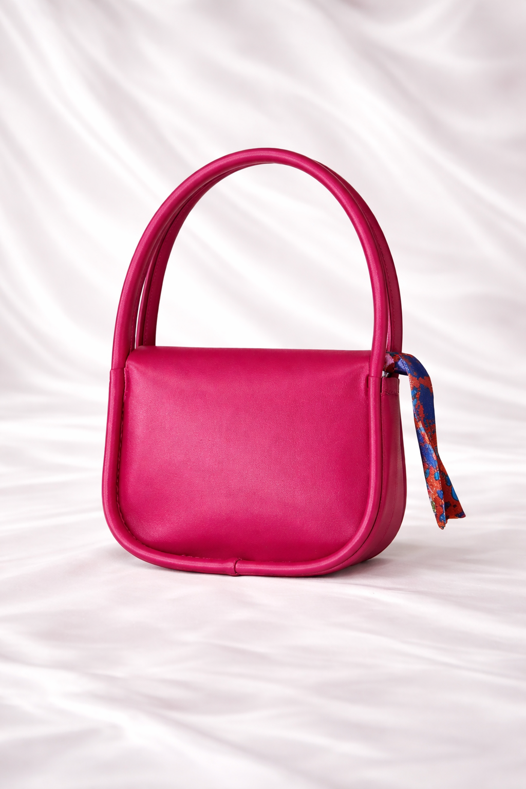 Close up of a Silslah mini handbag with silk scarf on handle and gold flap for little princess