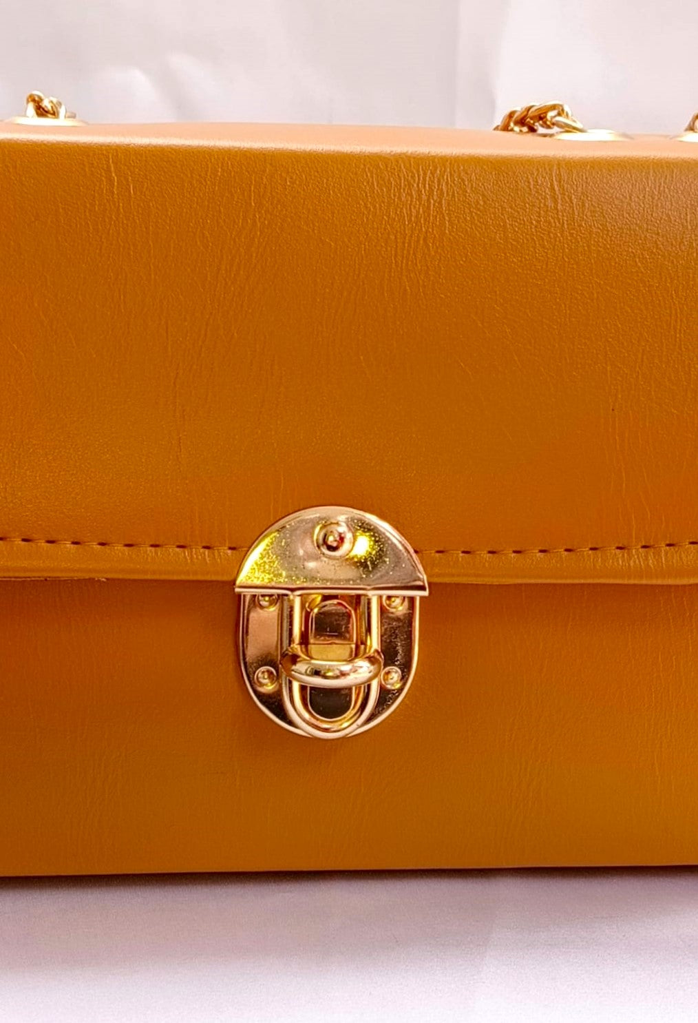 Trendy mustard shoulder bag in Pakistan featuring durable structure, gold hardware, and compact design for events and outings