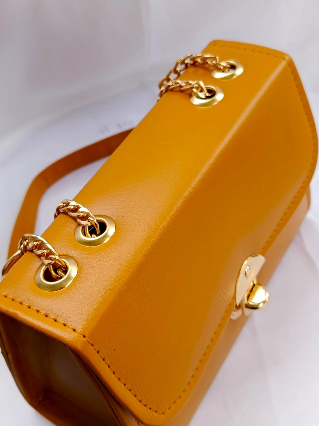 Trendy mustard amber handbag in Pakistan featuring durable structure, gold hardware, and compact design for events and outings