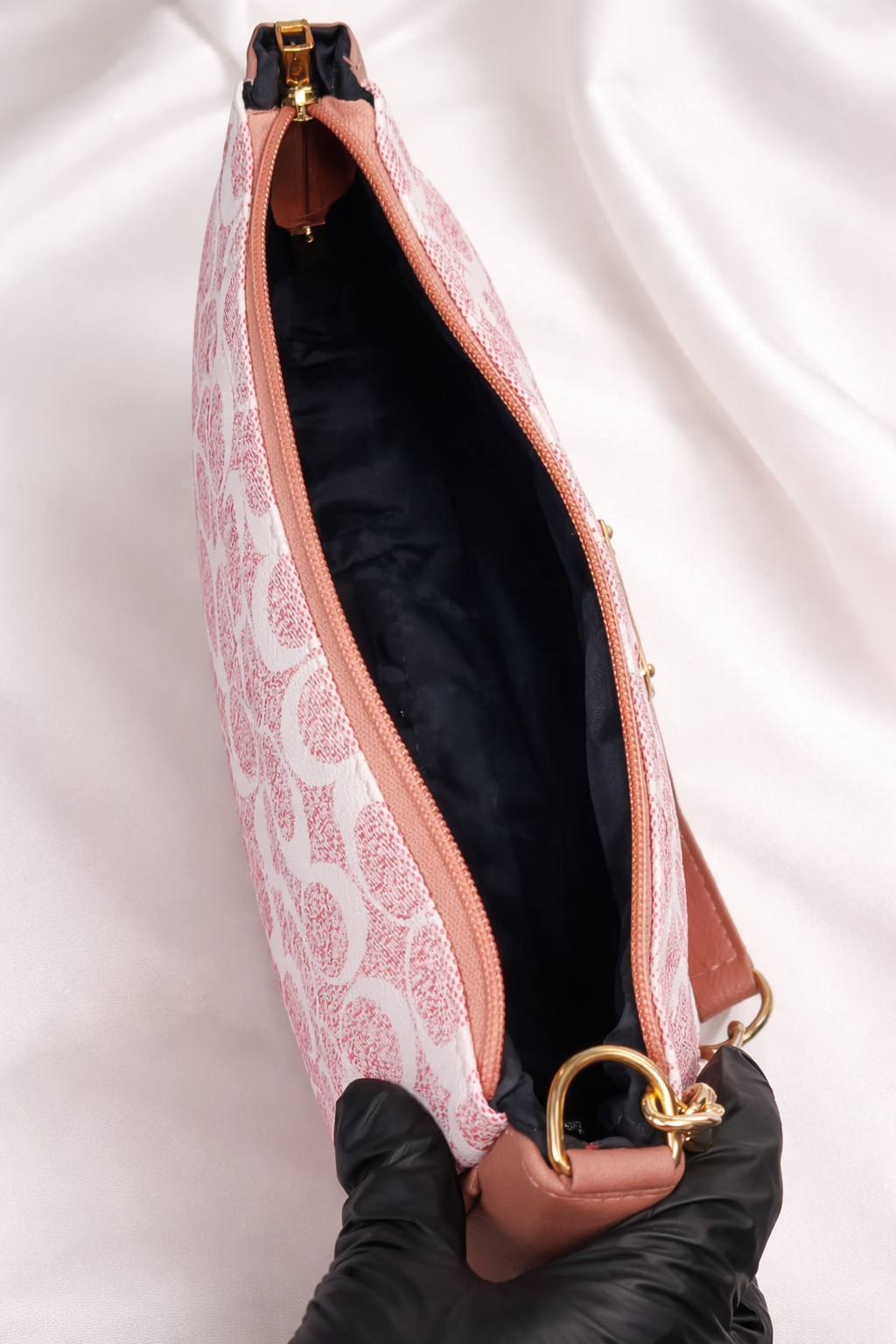 Close-up of a handbag with pink interior lining and gold detailing with large space 