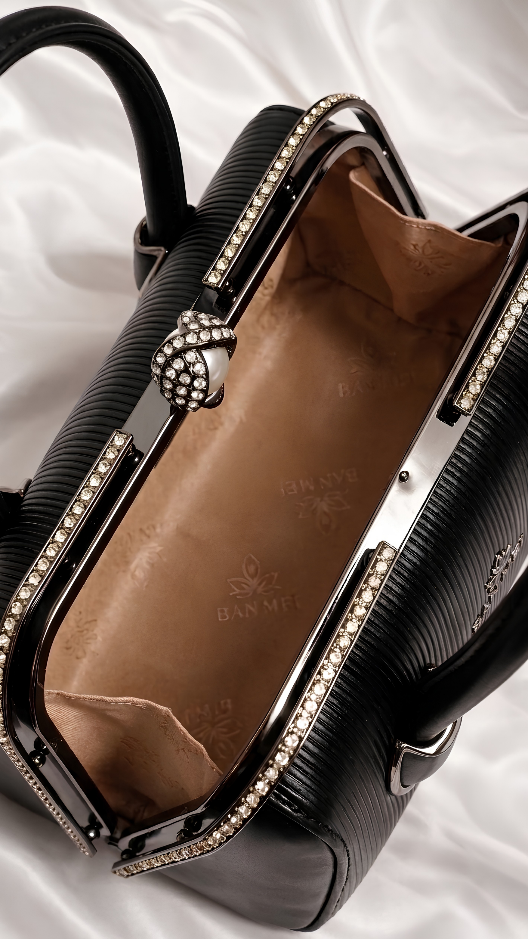 Spacious interior of black leather bag showing warm brown lining and metal frame