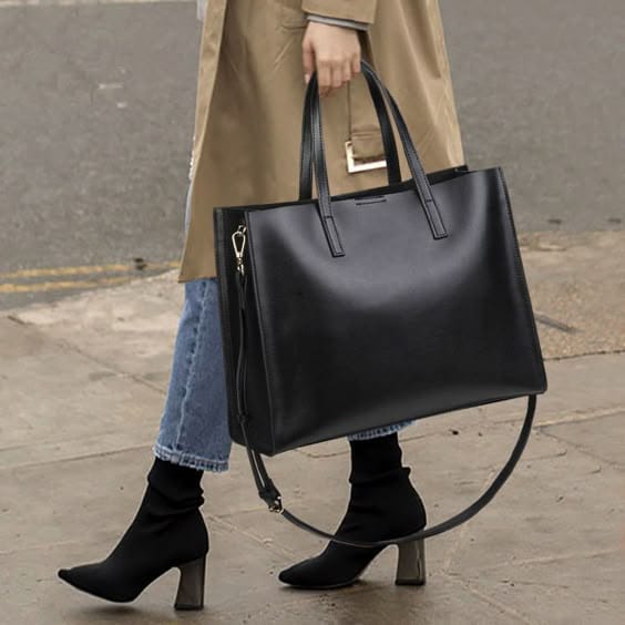 Person holding a black handbag on a city street