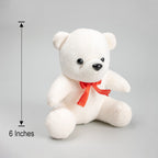 White teddy bear with a red bow and measurement label on a gray background